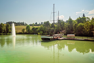 Lago di Monte Colombo con barca a vela e riflessi verdi &ndash; Rimini