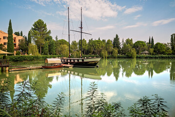 Lago di Monte Colombo con barca a vela e riflessi verdi &ndash; Rimini