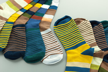 Colorful striped socks. Multicolored socks on a gray background. Autumn and winter clothing in the form of socks.