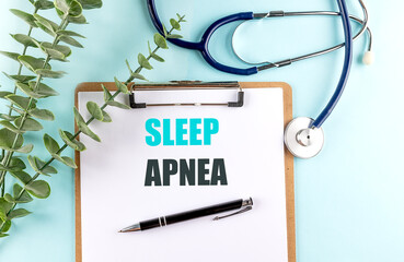 Clipboard with text sleep apnea on blue background with stethoscope, pen and eucalyptus branch