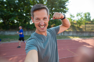 Smiling man taking selfie showing fitness progress