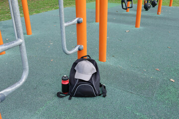 Calisthenics equipment in outdoor park with backpack and water bottle