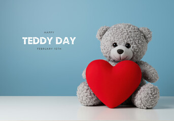 Grey teddy bear with red heart on blue background for Teddy Day plush toy stuffed animal