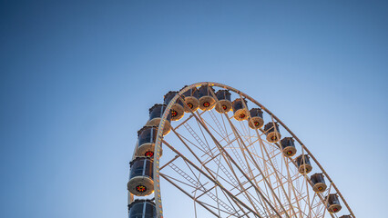 Giant Ferris Wheel Against Clear Blue Sky Capturing Joyful Amusement Park Vibe, Childhood Nostalgia, and Iconic Urban Entertainment Landmark