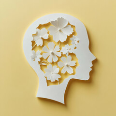 Silhouette of a head filled with paper flowers on a yellow background