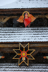Snowy Wooden Roof with Traditional Angel and Star Decorations