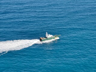 Fototapeta premium Highspeed patrol craft navigating azure waters with crew onboard