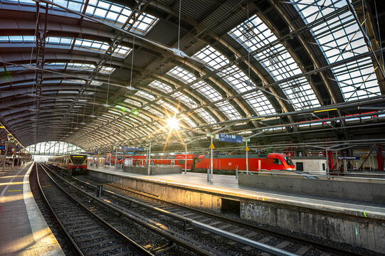 Berlin, Germany - December 26, 2025: Sun shining through the glass roof of Ostbahnhof railway station with regional trains on platforms