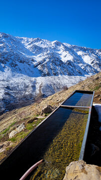 Water trough filled with qanat water in a snowy mountain landscape, surrounded by rugged slopes, winter terrain, and clear blue sky in a remote highland region.
📍Hawraman Takht, Kurdistan 