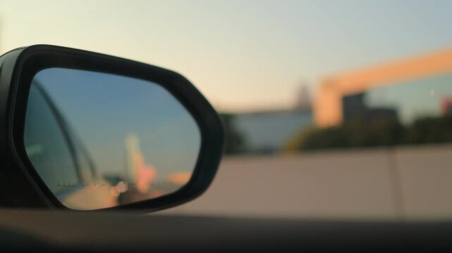 View in the side rearview mirror of a car driving on the city street.
Arabic caption: Objects in mirror are closer than they appear.