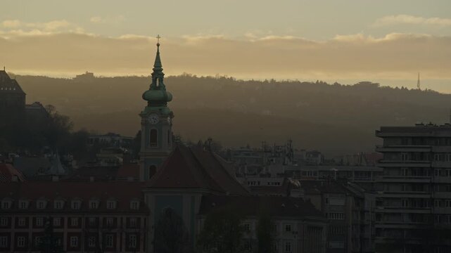 A Foggy Sunset Settles Over the Mountain-like City Hills and Historic Skyline, Bathed in Soft Golden Light in Budapest, Hungary - Static Shot