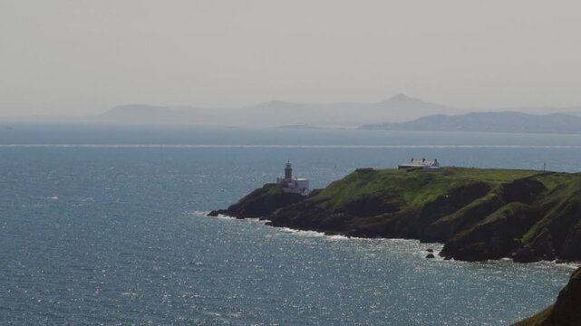 A Calm and Sunny View of the Sea and a Lighthouse in Ireland