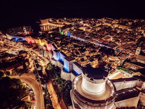 Aerial view of the illuminated ancient walls and terracotta rooftops of Dubrovnik Old Town, a jewel of the Adriatic coast under a starlit sky, Dubrovnik, Dubrovnik-Neretva County, Croatia.