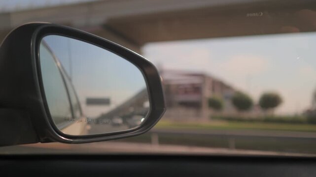 Car in motion. View in the side rearview mirror of a car driving on the highway.
Arabic caption: Objects in mirror are closer than they appear.