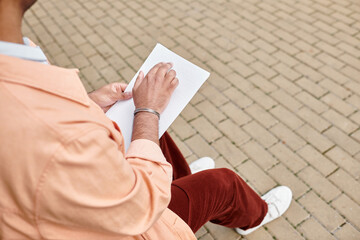 Handsome Indian man exploring creativity through braille on a sunny day outdoors © LIGHTFIELD STUDIOS