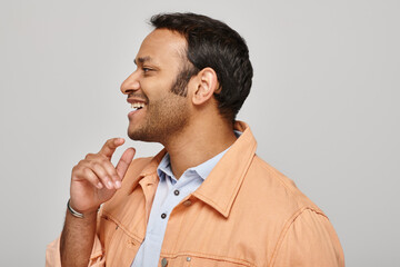 Handsome Indian man smiling warmly while engaging in conversation, showcasing joy and charm