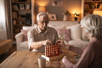 Senior Couple Plays Connect Four Board Game in Cozy Living Room