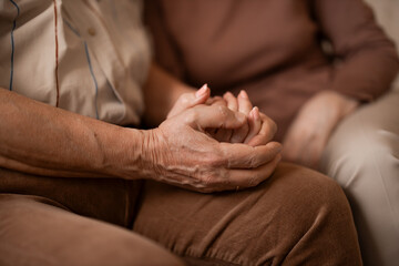 Fototapeta premium Tender Hands Holding Hands Between Elderly And Family Member In A Warm Home Setting