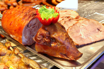 Grilled suckling piglet in spit roast. Traditional whole pig roasted on barbecue spit. Popular delicious and crispy roasted piggy on christmas fair