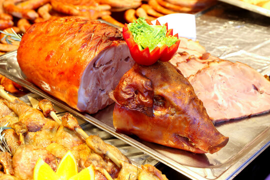 Grilled suckling piglet in spit roast. Traditional whole pig roasted on barbecue spit. Popular delicious and crispy roasted piggy on christmas fair