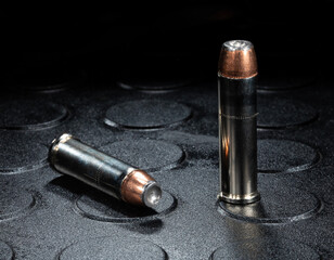 Two hollow point .357 Magnum cartridges on a dark surface