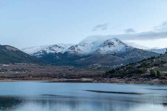 Sunrise at the Navacerrada reservoir with the Sierra de Guadarrama mountains covered in snow