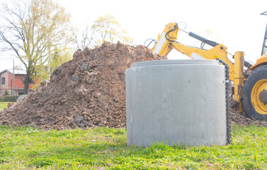 Installation of a reinforced concrete well for water supply and sewerage at a construction site. Well concrete ring for a well.