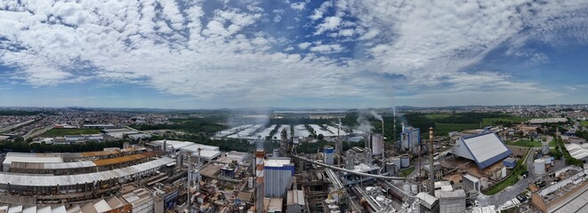 Vista a&eacute;rea de complexo industrial de papel e celulose com chamin&eacute;s e caldeiras em atividade, representando produ&ccedil;&atilde;o em larga escala e forte presen&ccedil;a industrial.