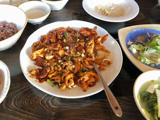 Spicy Korean Jjukkumi Stir Fry with Vegetables Served as a Traditional Korean Main Dish on a Wooden Table