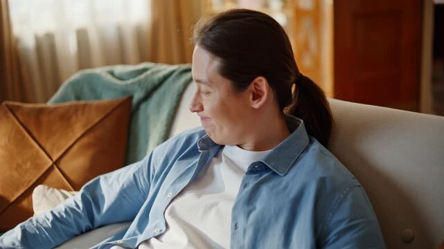 Fatigued brunette falling couch closeup. Handsome guy touching forehead at home