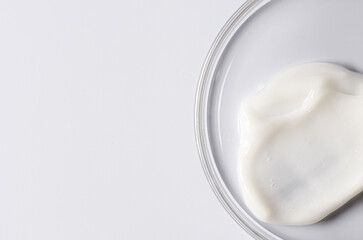Moisturizing cosmetic skin cream in a Petri dish. Copy space