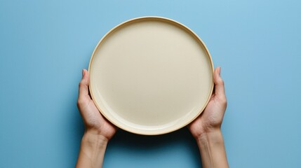 Empty Round Plate Held by Hands Against a Blue Background in a Minimalistic Style for Culinary and Restaurant Themes