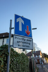 Priority road sign with arrows and houses