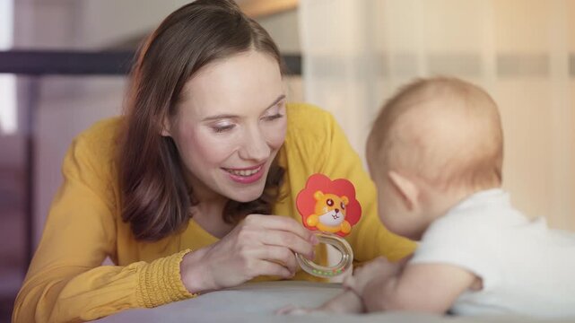 Mother showing teething toy to baby, supporting sensory development