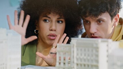 Creative builders discussing models residential complex in office closeup.