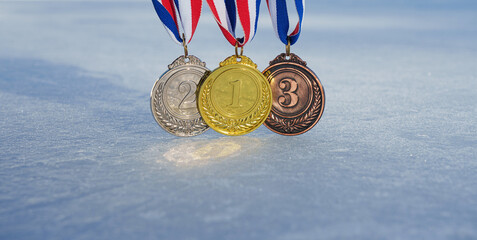 golden medal on the textured ice surface in the snow - winter sport successful concept