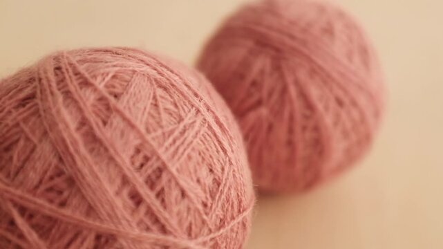 Wool yarn thread for knitting and crocheting. Warm clothes knitting hobby and crafts, slow living concept, textile industry. Closeup slow motion aesthetic video.