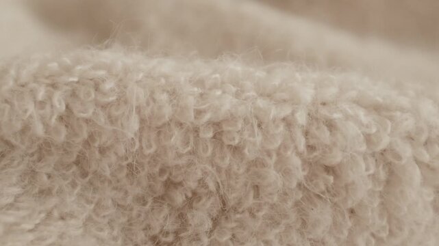 Closeup aesthetic video of hands touching soft wool sweater. Ivory fluffy knitted sweater for cold winter. Appreciating pleasant texture of high quality clothes. Soft and cosy clothes. 
