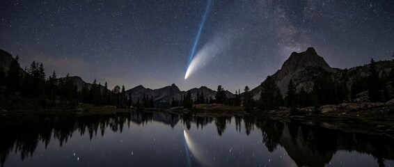 A breathtaking celestial event: a comet streaks across the night sky, reflected in the still waters of a tranquil lake, framed by majestic mountains.