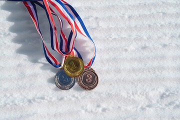 golden medal on the textured ski slopes in the snow - winter sport successful concept. Skiing, biathlon.