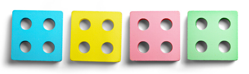 Colorful wooden square blocks with four holes, arranged in a row on a white background. Concept of...