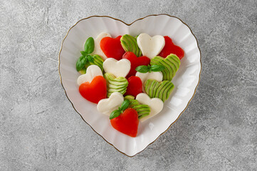 Heart-shaped caprese salad with mozzarella, tomatoes, avocado and basil. A salad for Valentine's Day or Mother's Day. Top view, copy space.