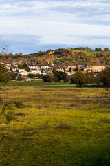 Obraz premium Historic center of Carbonne within a bend of the Garonne River, dominated by hillsides at the end of autumn