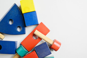 Colorful collection of wooden educational toys in various shapes stacked on a white background. Early childhood development, learning through play, and creative building