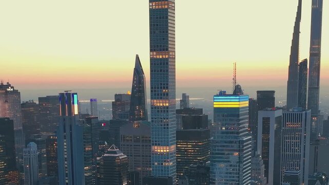 Sunset view of New York City skyline with tall buildings and lights