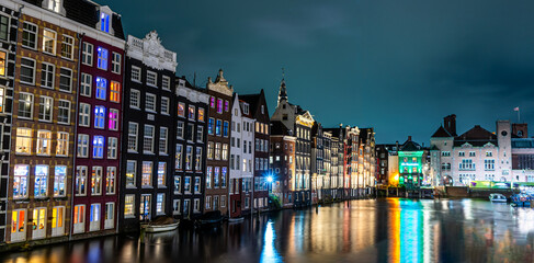 Amsterdam night. Colorful houses canal water reflection