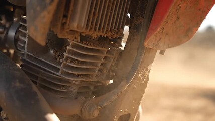 Close-up cinematic shot revealing the rugged, mud-splattered engine and cooling fins of an off-road motorcycle after a thrilling ride, showcasing its endurance and the challenges of the trail - Powered by Adobe