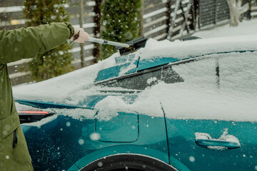 Brushing Snow Off a Car Windshield in Winter