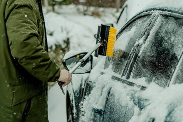 Brushing Snow Off a Car Windshield in Winter