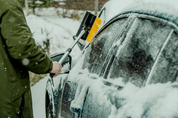 Brushing Snow Off a Car Windshield in Winter